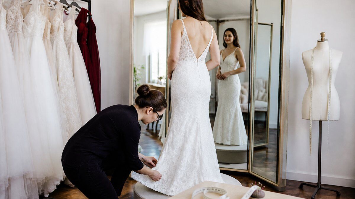 Step-by-step diagram illustrating the process of pinning and adjusting a wedding dress hem during a bridal fitting